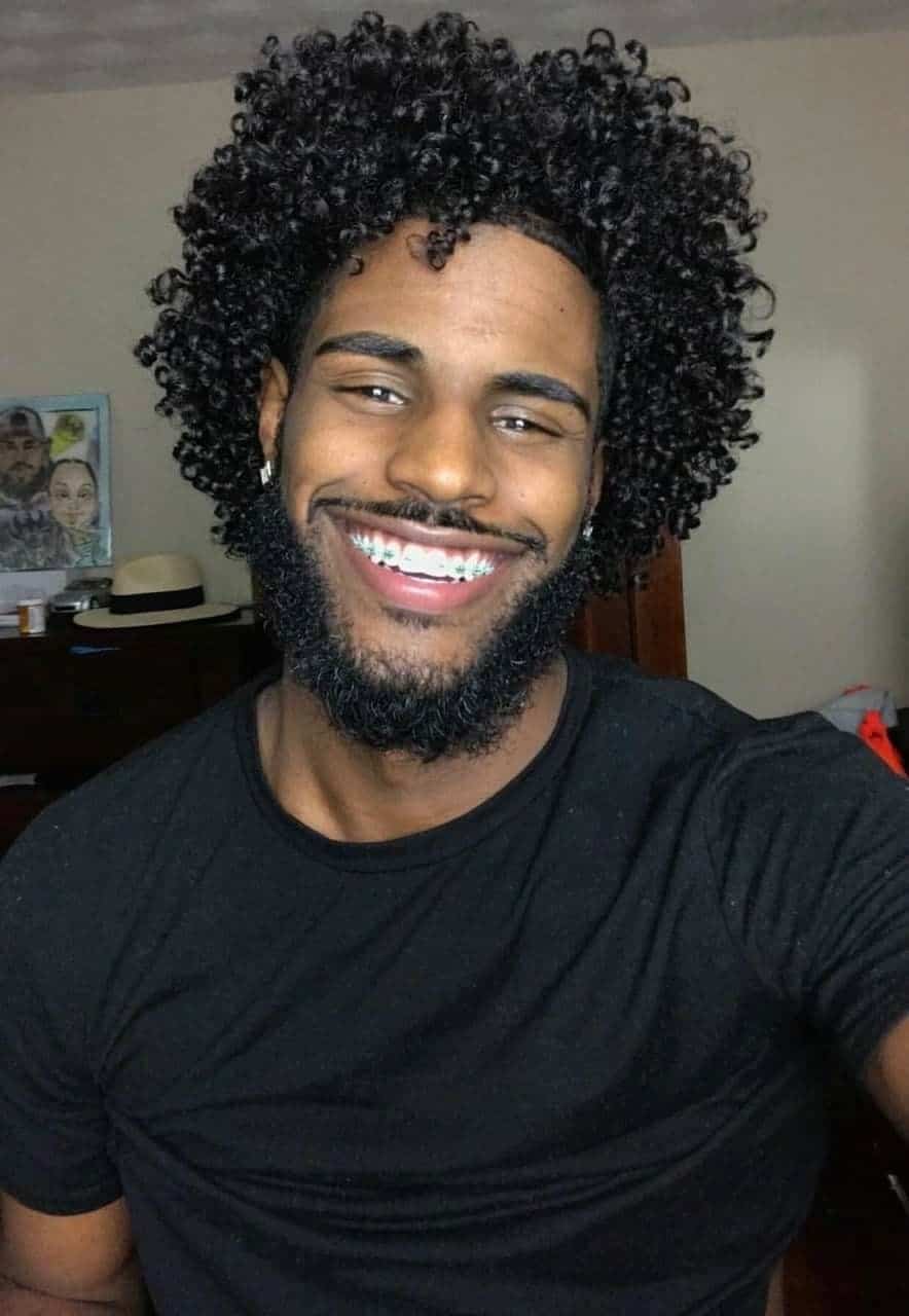 homem negro com corte de cabelo black power sorrindo
