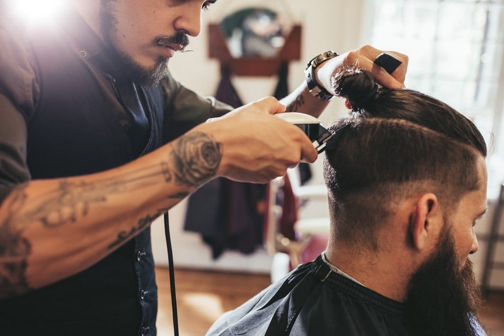  barbeiro fazendo um corte de Cabelo Masculino com risco