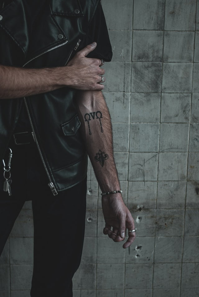 Homem com tatuagem pequena no antebraço