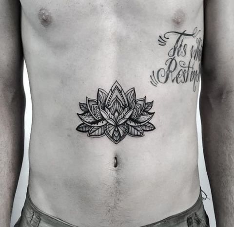 tatuagem masculina flor de lótus na barreguinha

