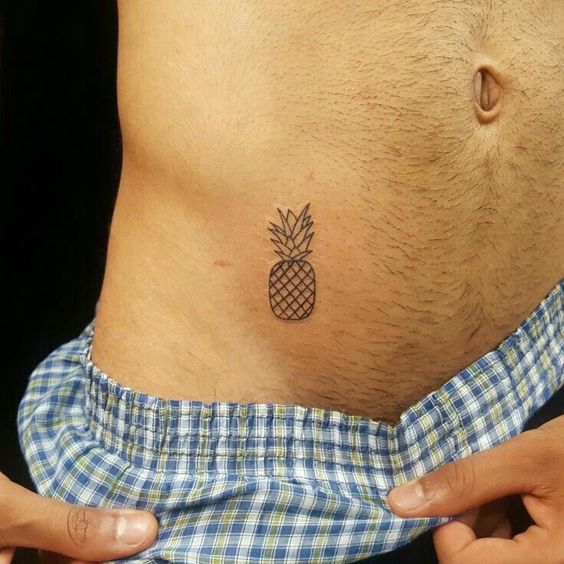 Close em uma tatuagem próxima a virilha de um abacaxi