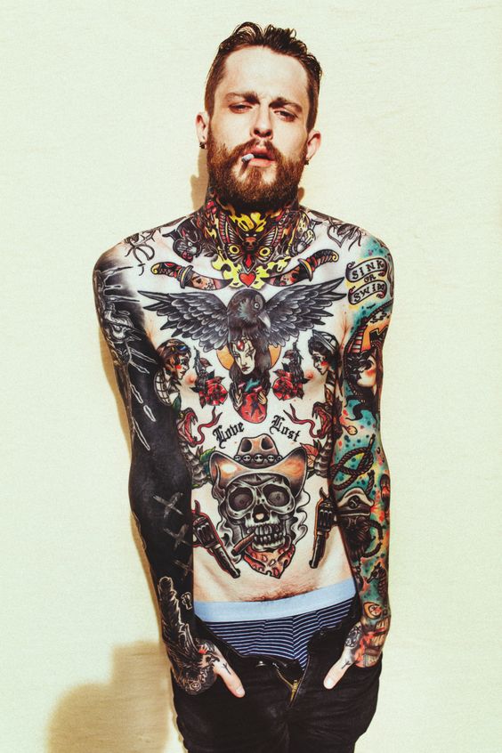 Homem todo tatuado com alguns tatuagens oldschool na virilha.