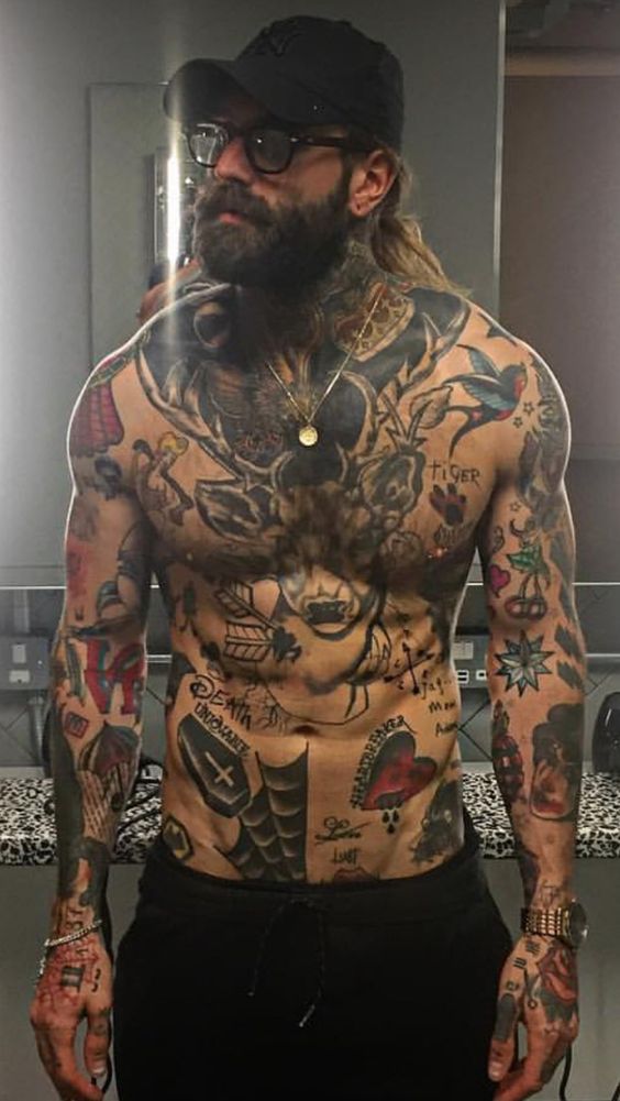 Homem todo tatuado com alguns tatuagens oldschool na virilha.