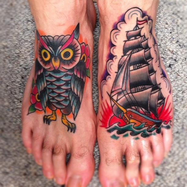 Close em par de pés com tatuagens coloridos oldschool, uma coruja e um galeão.