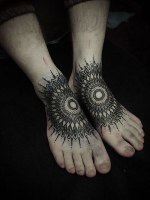 Close em pés com tatuagens de  mandala.