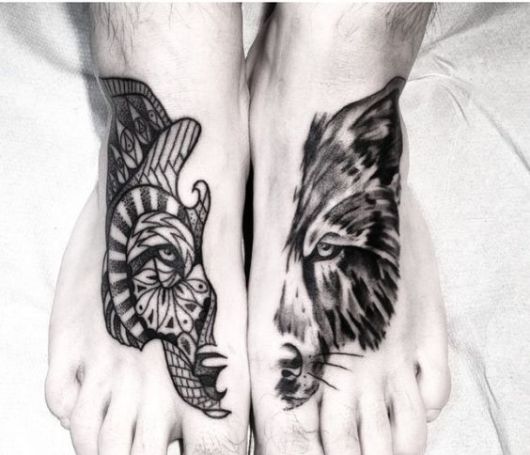 Close em pés com tatuagens complementares, duas metades do rosto completo de um lobo, cada  um com um estilo de tattoo.