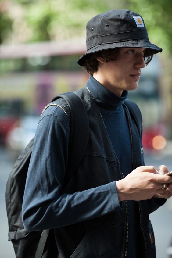 chapéu bucket masculino preto em  rapaz branco  com roupas de frio