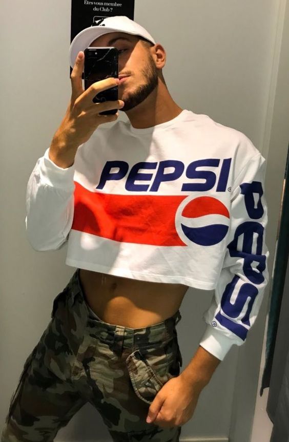 Rapaz latino de boné tirando selfie com cropped masculino branco da Pepsi.