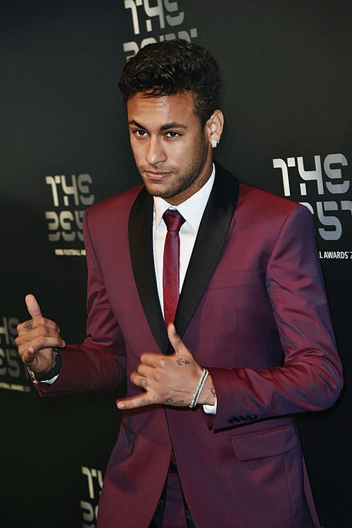 Neymar fazendo hanglose com as mãos  e vestindo um terno vinho