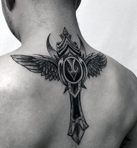 Close em uma tatuagem de cruz estilizada com  asas