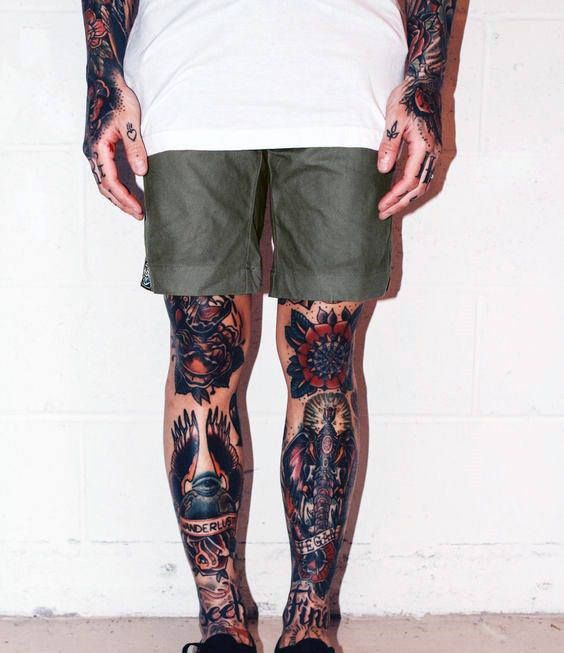 Homem com perna completamente tatuada com várias artes em oldschool.